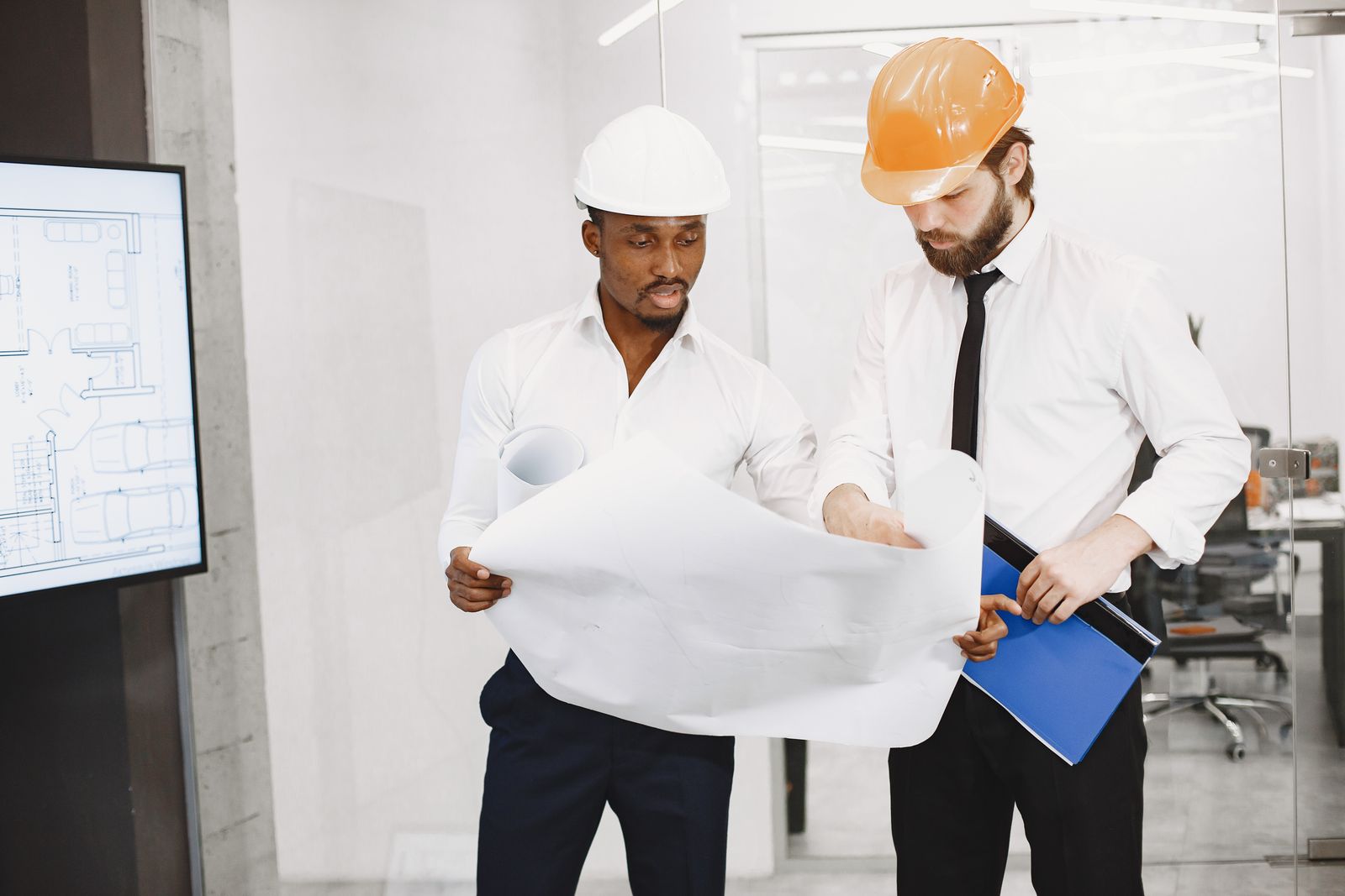 Professionnels examinant des plans pour préparer un projet de bâtiment